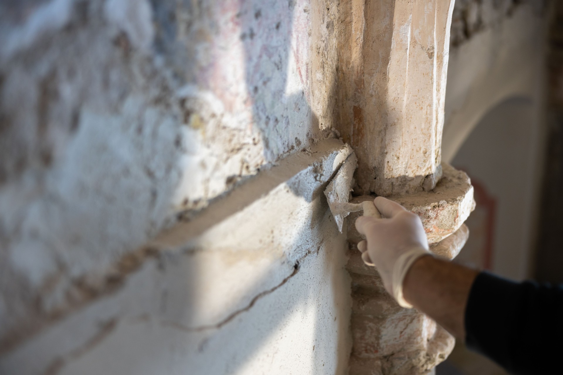 Professional Restorer Hand in Restore Work on Gothic Church Columns and Walls